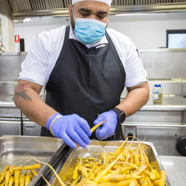 Chef preparing baby parsnips in the kitchen at Mercy Place Parkville